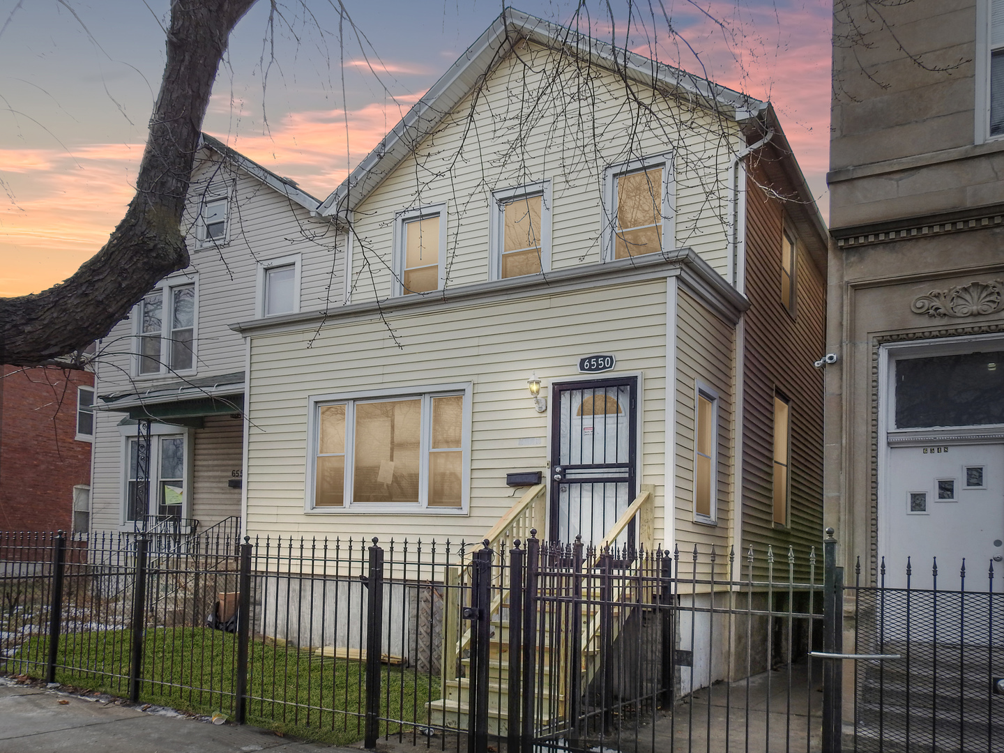 a front view of a house with iron fence