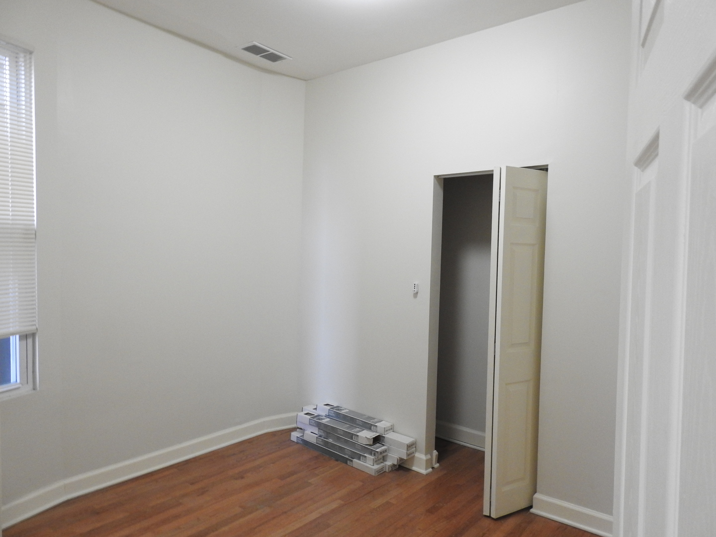6550 South Perry Avenue Chicago, IL 60621 - Photo 2 of 6 an empty room with wooden floor and closet