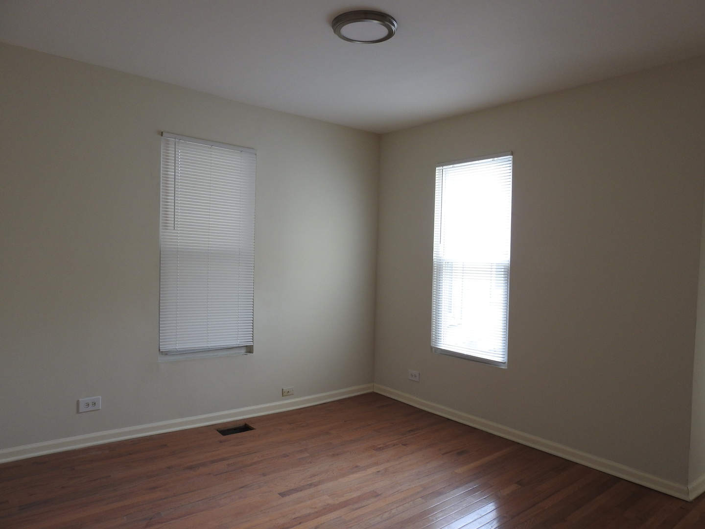 6550 South Perry Avenue Chicago, IL 60621 - Photo 3 of 6 an empty room with wooden floor and windows