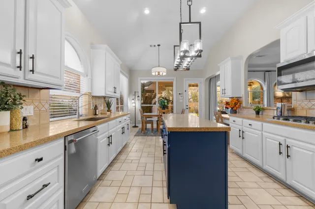a large kitchen with stainless steel appliances lots of counter space and wooden floor