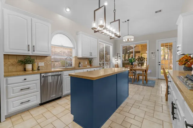 a kitchen with kitchen island granite countertop a sink window and cabinets