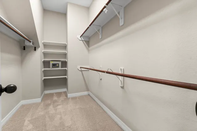 a view of walk in closet with empty racks