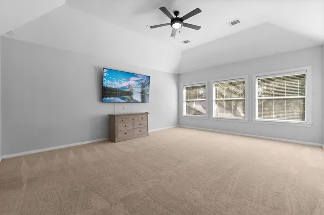 an empty room with windows and ceiling fan