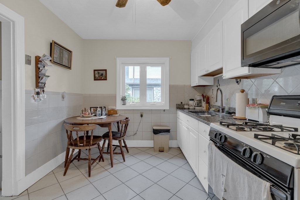 67 Bruce Road Waltham, MA 02453 - Photo 7 of 17 a kitchen with stainless steel appliances a white table and chairs in it