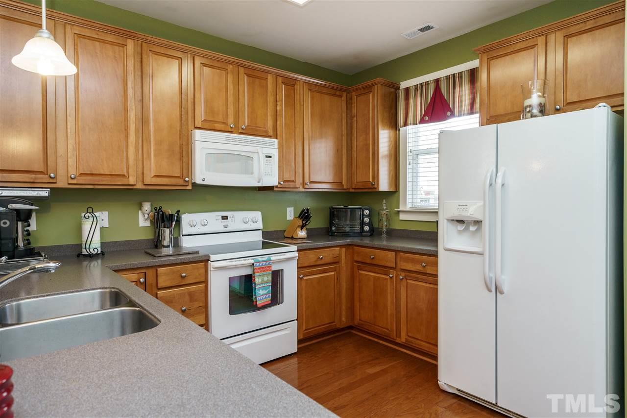 4422 Crystal Breeze Street Raleigh, NC 27614 - Photo 11 of 25 a kitchen with stainless steel appliances granite countertop a stove a sink and a refrigerator