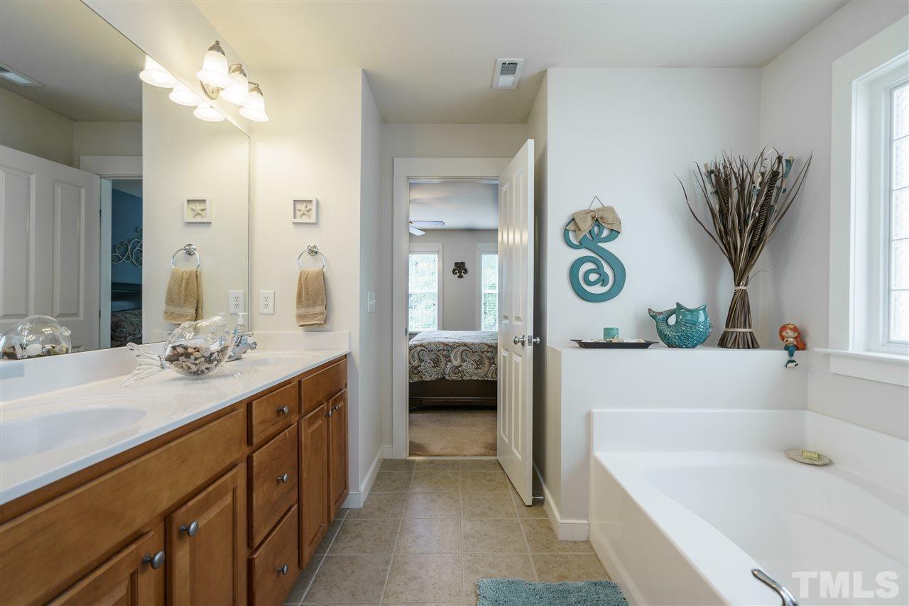 4422 Crystal Breeze Street Raleigh, NC 27614 - Photo 19 of 25 a en suite spacious bathroom with a granite countertop tub and a sink