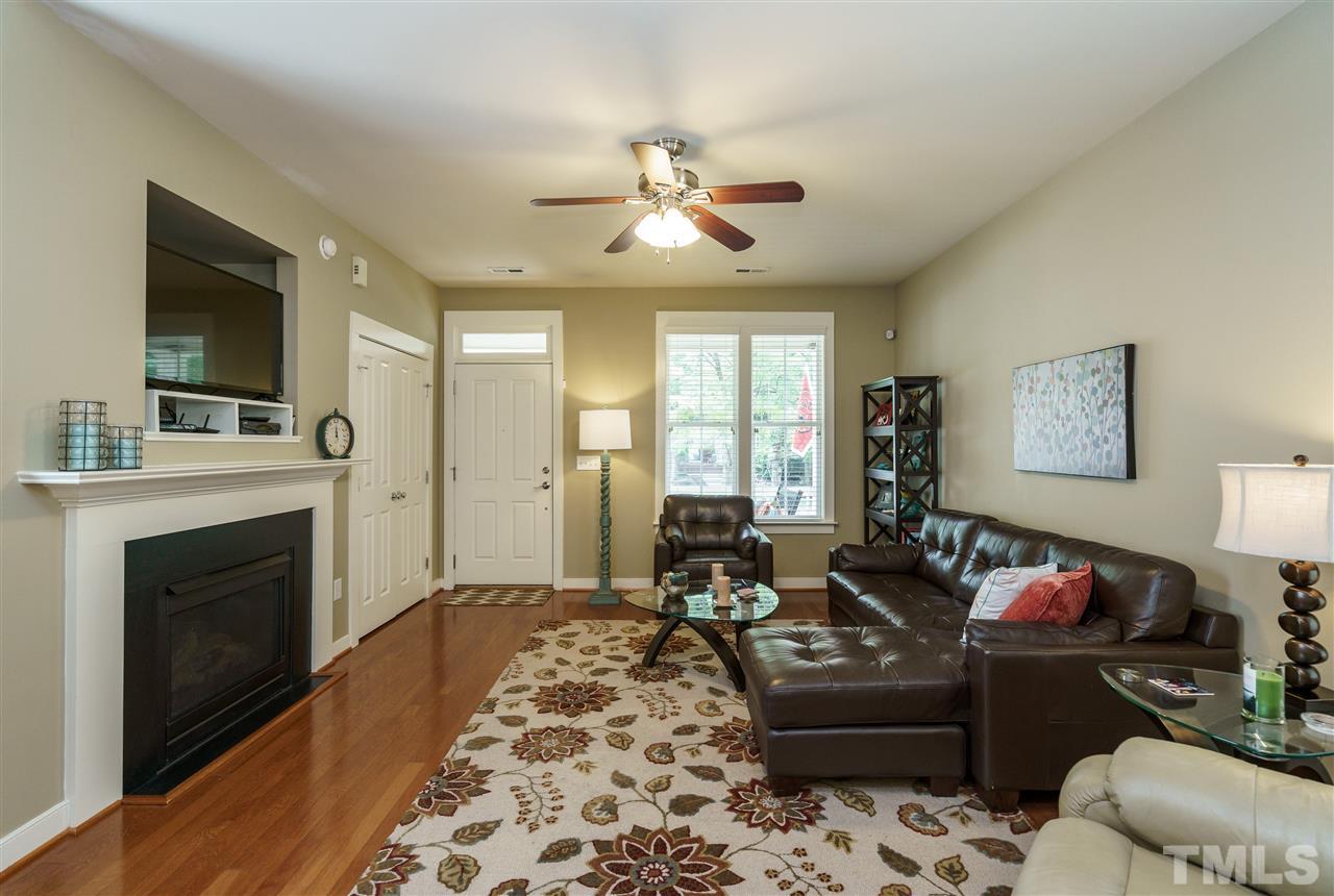 4422 Crystal Breeze Street Raleigh, NC 27614 - Photo 7 of 25 a living room with furniture a flat screen tv and a fireplace