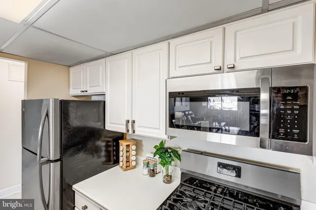 a kitchen with stainless steel appliances granite countertop a refrigerator and a stove