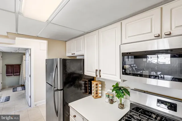 a kitchen with stainless steel appliances a refrigerator a sink a stove and cabinets