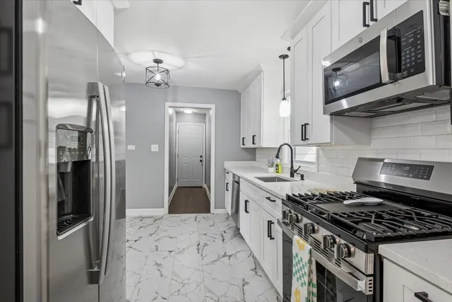 a kitchen with stainless steel appliances granite countertop a stove a refrigerator and a sink