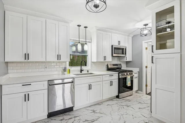 a kitchen with stainless steel appliances granite countertop a stove sink and cabinets