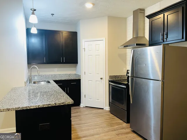 a kitchen with granite countertop a refrigerator and a sink