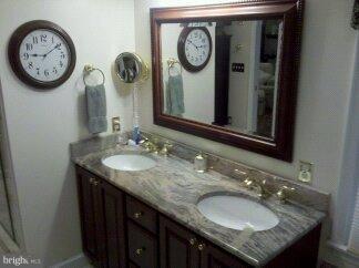 2676 Walston Road Mount Airy, MD 21771 - Photo 8 of 28 a bathroom with a granite countertop sink and a large mirror