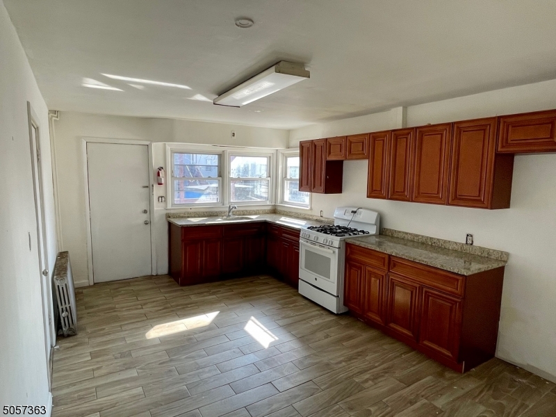 177 Beech Street Paterson, NJ 07501 - Photo 1 of 10 a kitchen with stainless steel appliances granite countertop a sink counter space cabinets and a window