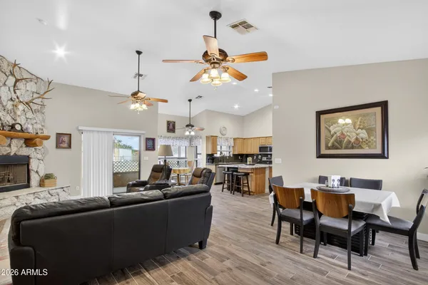 a living room with furniture kitchen view and a chandelier
