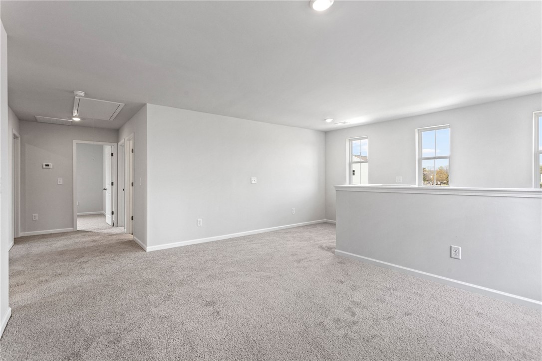 146 Cedar Shoals Easley, SC 29640 - Photo 19 of 34 This spacious loft area features ample natural light and plush carpeting, offering versatile living space.