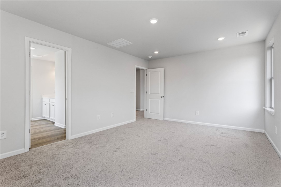 146 Cedar Shoals Easley, SC 29640 - Photo 22 of 34 This spacious bedroom offers ample natural light and plush carpeting, creating a serene and inviting atmosphere.