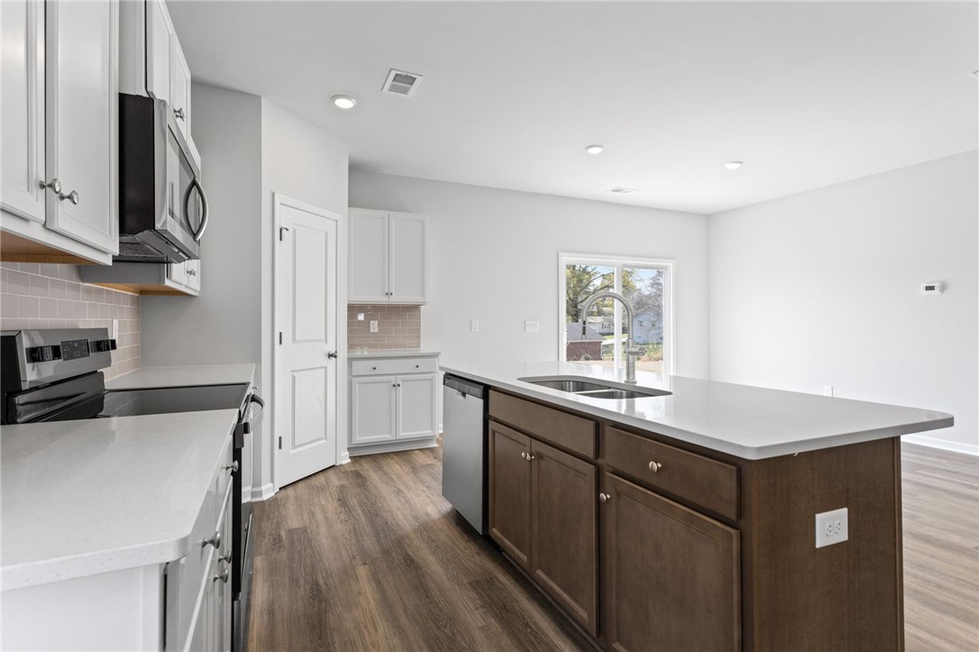 146 Cedar Shoals Easley, SC 29640 - Photo 10 of 34 This modern kitchen features warm wood flooring and a bright, open layout perfect for daily living.