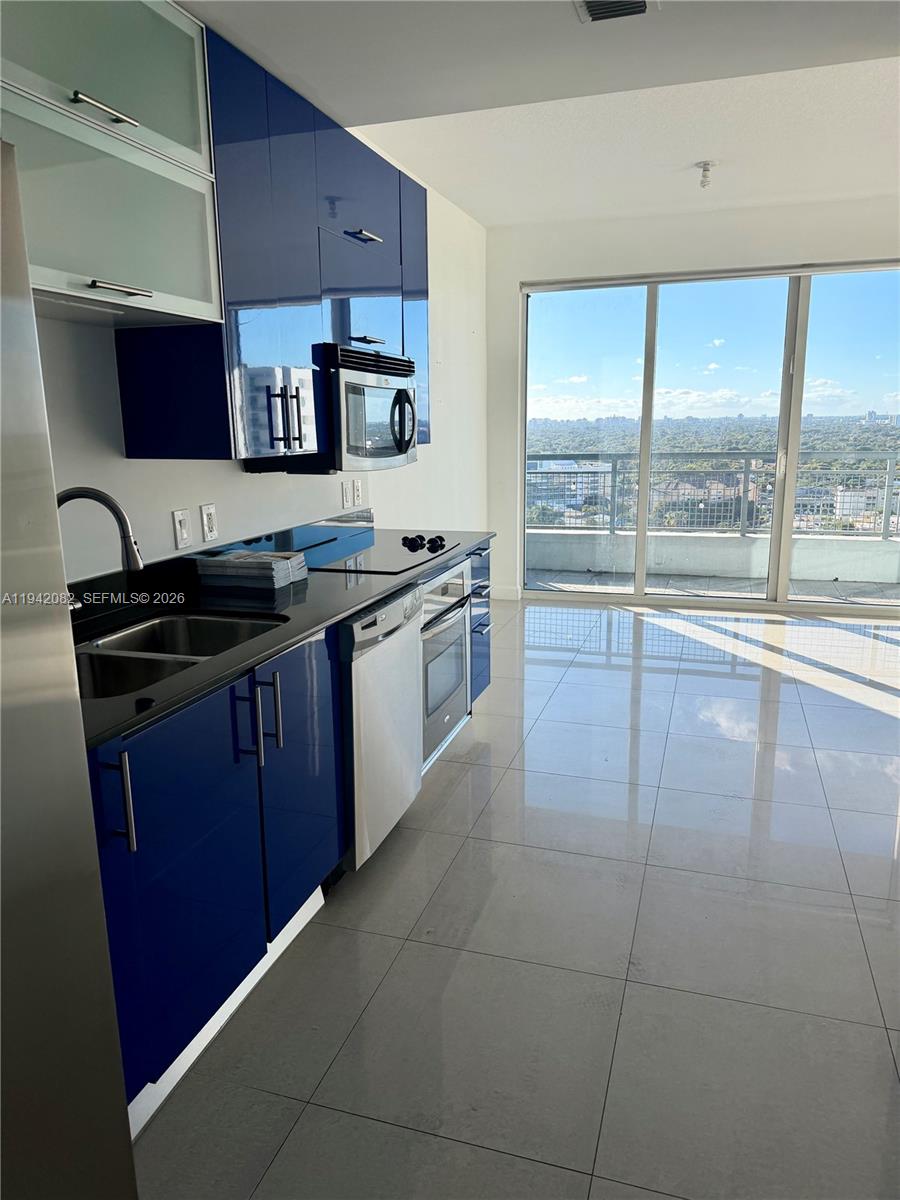 60 Southwest 13th Street, Unit 1519 Miami, FL 33130 - Photo 5 of 6 a kitchen with a stove a sink and a microwave
