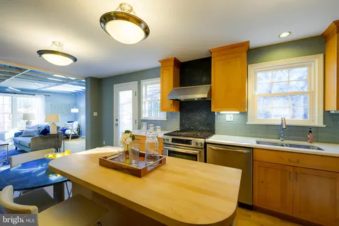 a bed sitting in a bedroom next to a window and a chair