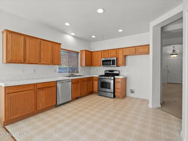 a kitchen with stainless steel appliances granite countertop a refrigerator sink and cabinets