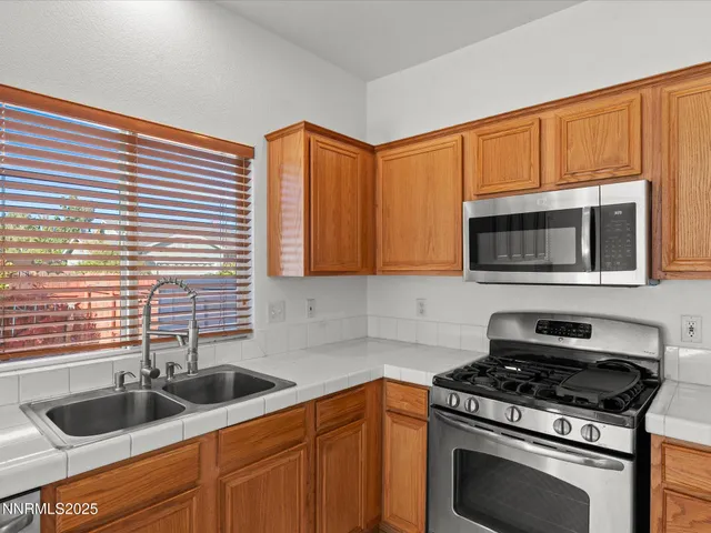 a kitchen with granite countertop cabinets stainless steel appliances and a sink