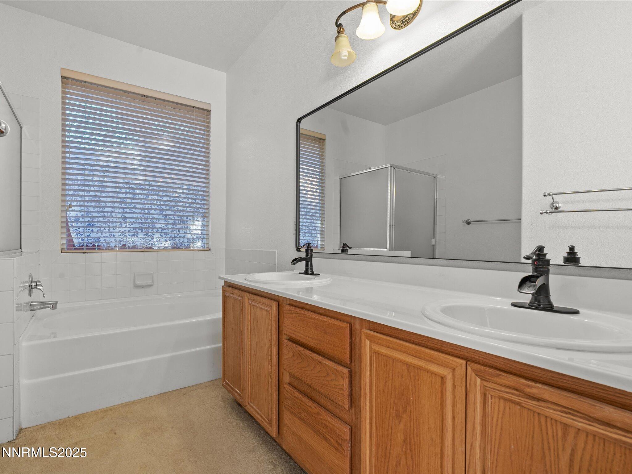 805 Sauvignon Drive Reno, NV 89506 - Photo 24 of 56 a bathroom with a tub sink and mirror