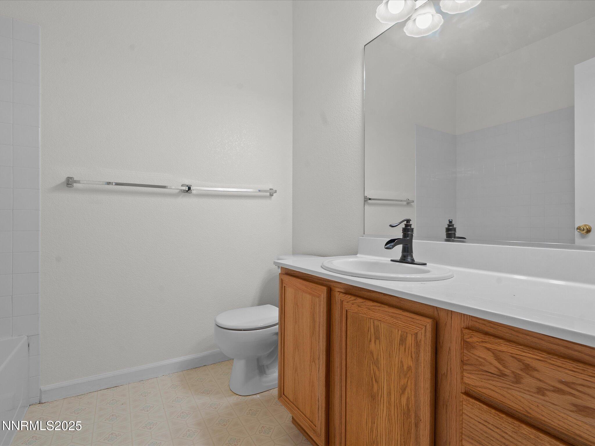 805 Sauvignon Drive Reno, NV 89506 - Photo 32 of 56 a bathroom with a granite countertop sink a toilet and a mirror