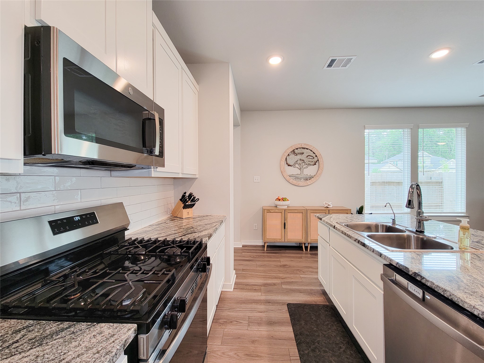 2818 Bluebonnet Ridge Drive Conroe, TX 77304 - Photo 1 of 42 a kitchen with stainless steel appliances a stove a sink and a microwave