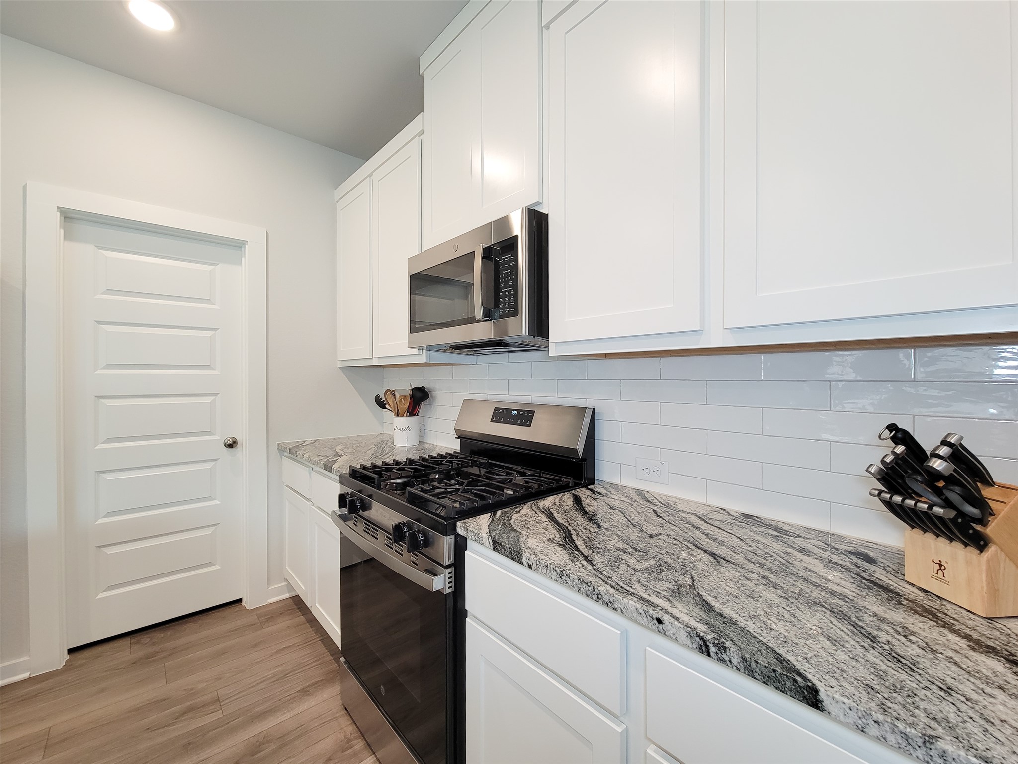 2818 Bluebonnet Ridge Drive Conroe, TX 77304 - Photo 12 of 42 a kitchen with granite countertop cabinets and steel stainless steel appliances