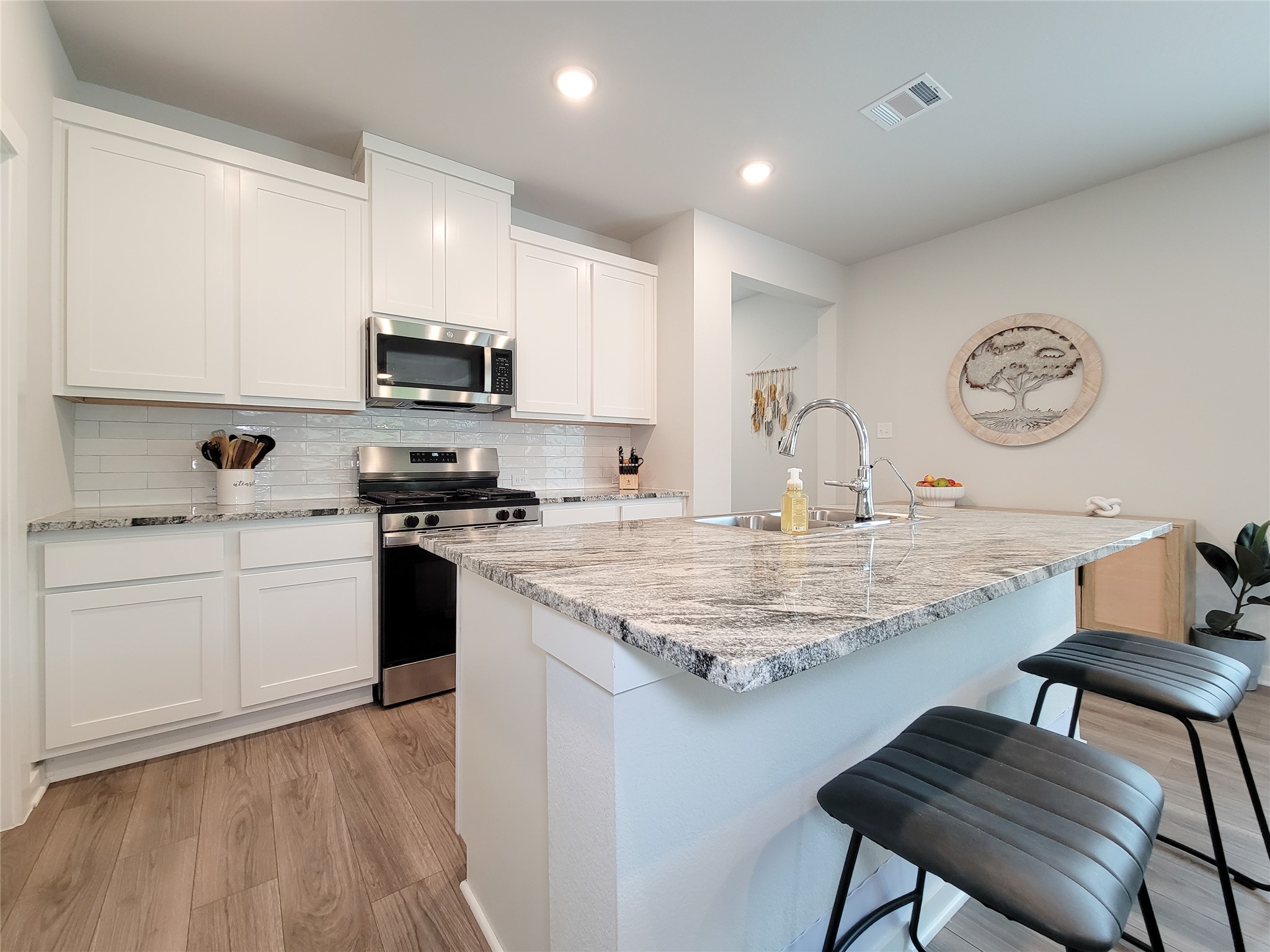 2818 Bluebonnet Ridge Drive Conroe, TX 77304 - Photo 14 of 42 a kitchen with stainless steel appliances granite countertop a white cabinets a stove top oven a sink and dishwasher