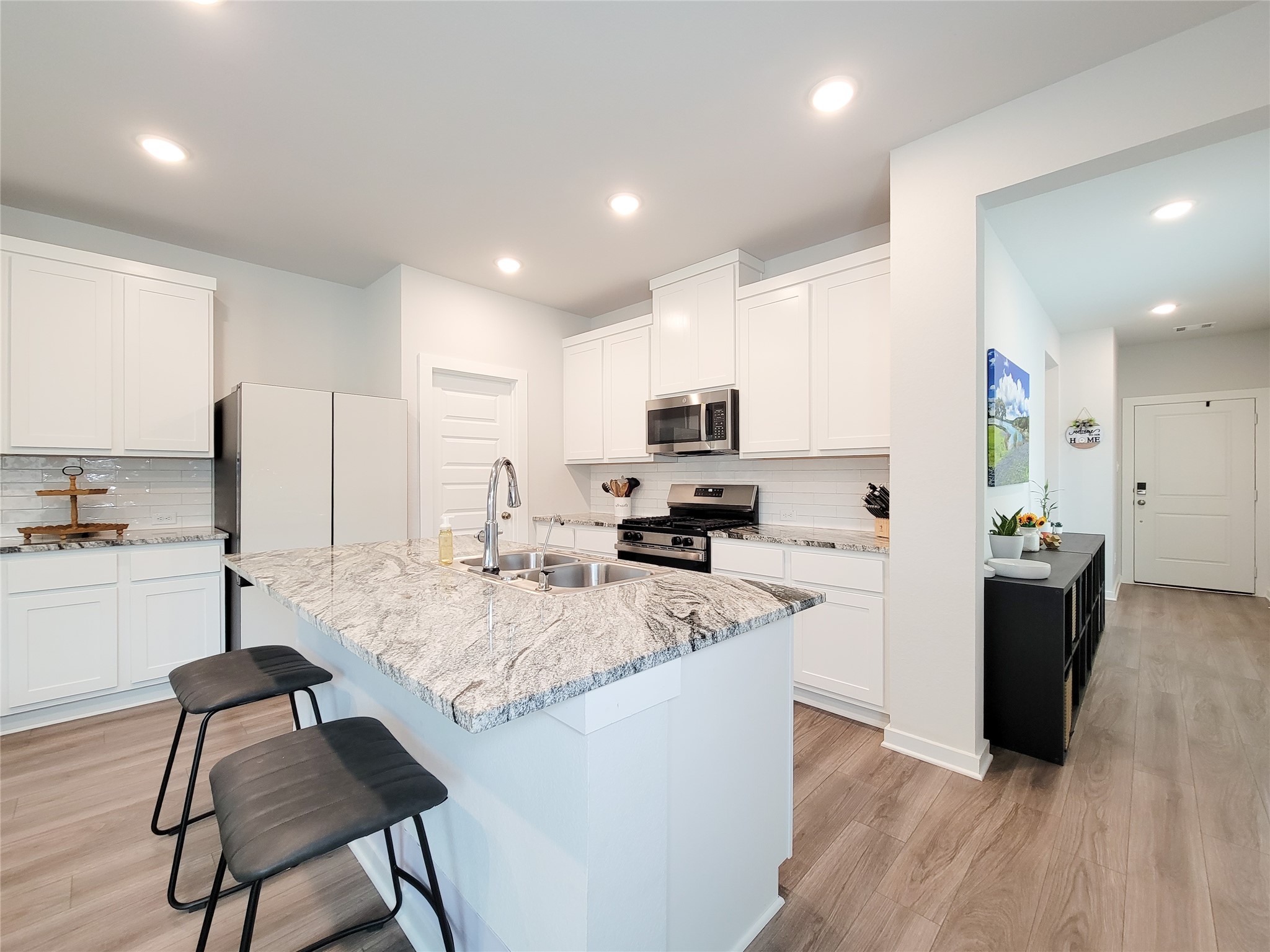 2818 Bluebonnet Ridge Drive Conroe, TX 77304 - Photo 15 of 42 a kitchen with stainless steel appliances kitchen island granite countertop a sink refrigerator and cabinets
