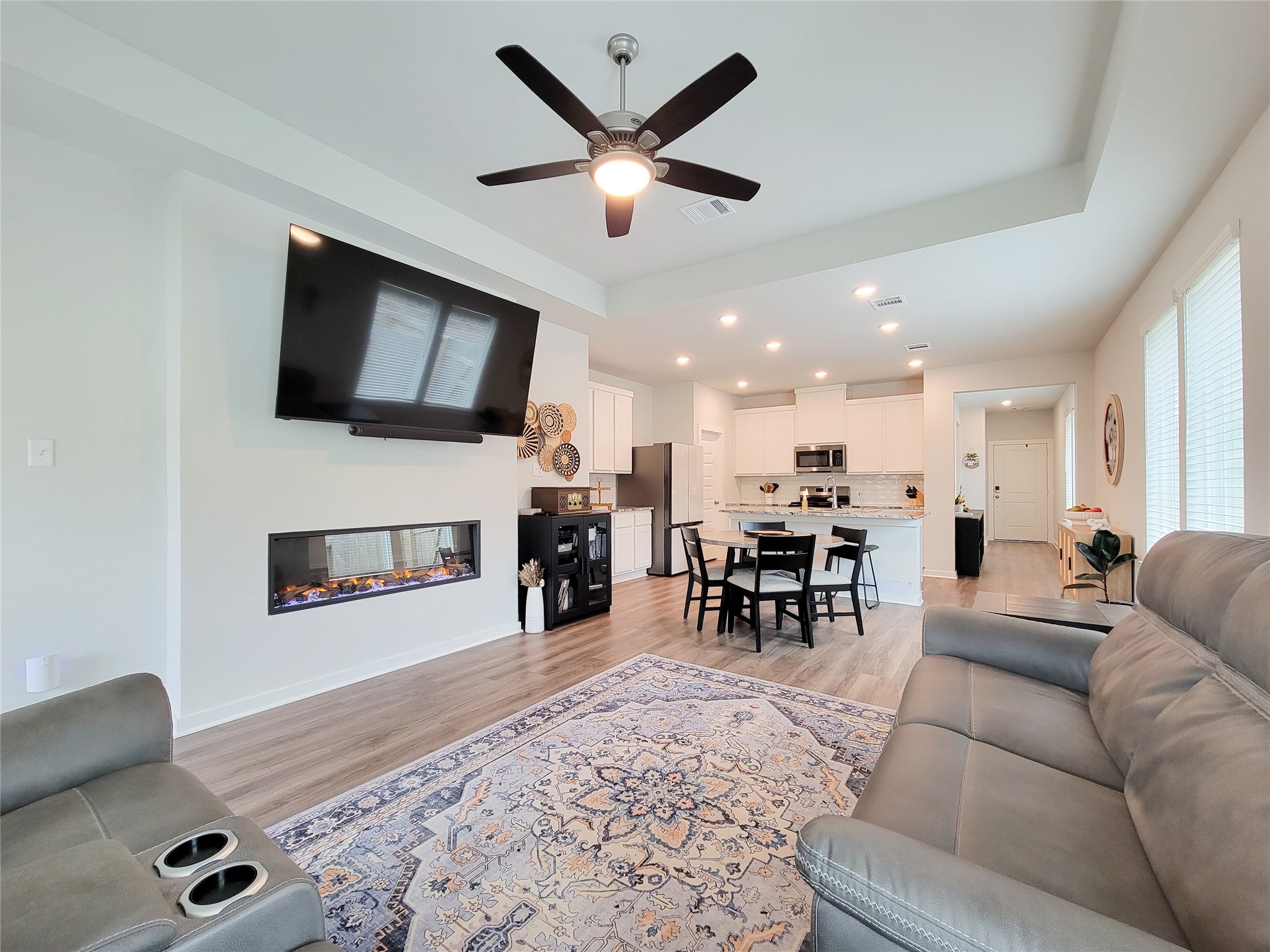2818 Bluebonnet Ridge Drive Conroe, TX 77304 - Photo 20 of 42 a living room with furniture and a flat screen tv with kitchen view