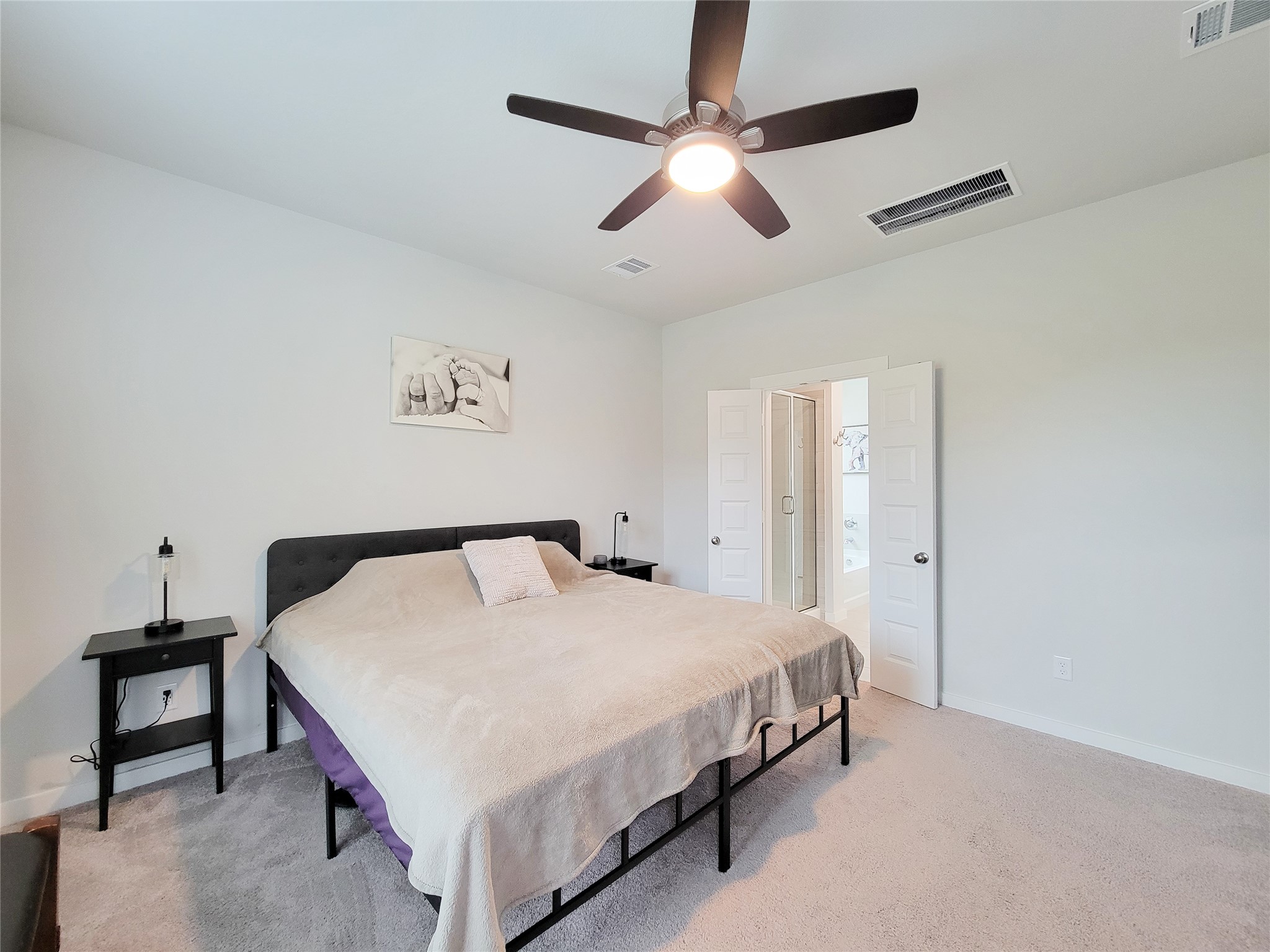 2818 Bluebonnet Ridge Drive Conroe, TX 77304 - Photo 24 of 42 a bedroom with a bed and a chandelier