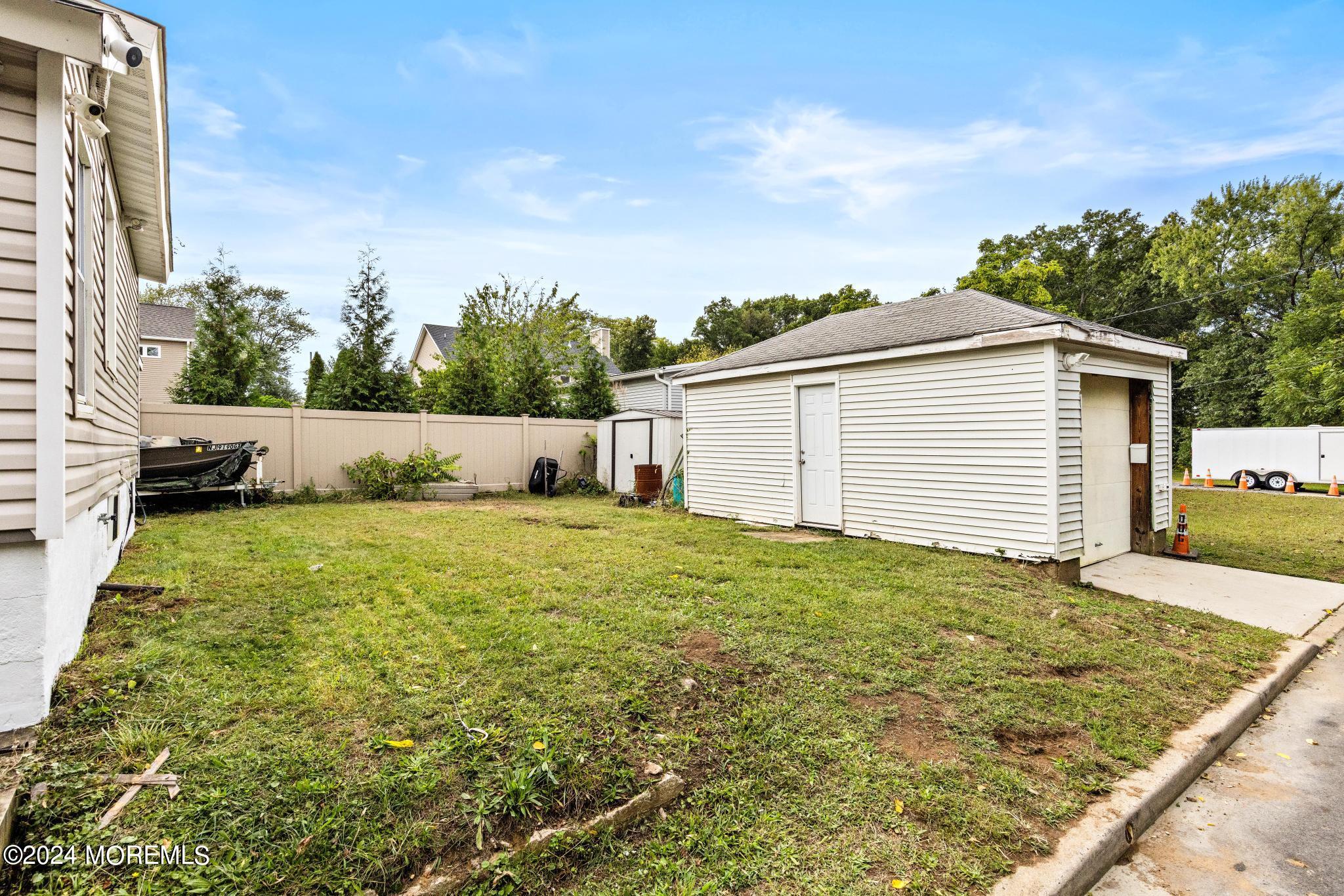 71 Highfield Avenue Matawan, NJ 07747 - Photo 21 of 24 a view of a backyard with table and chairs and wooden fence