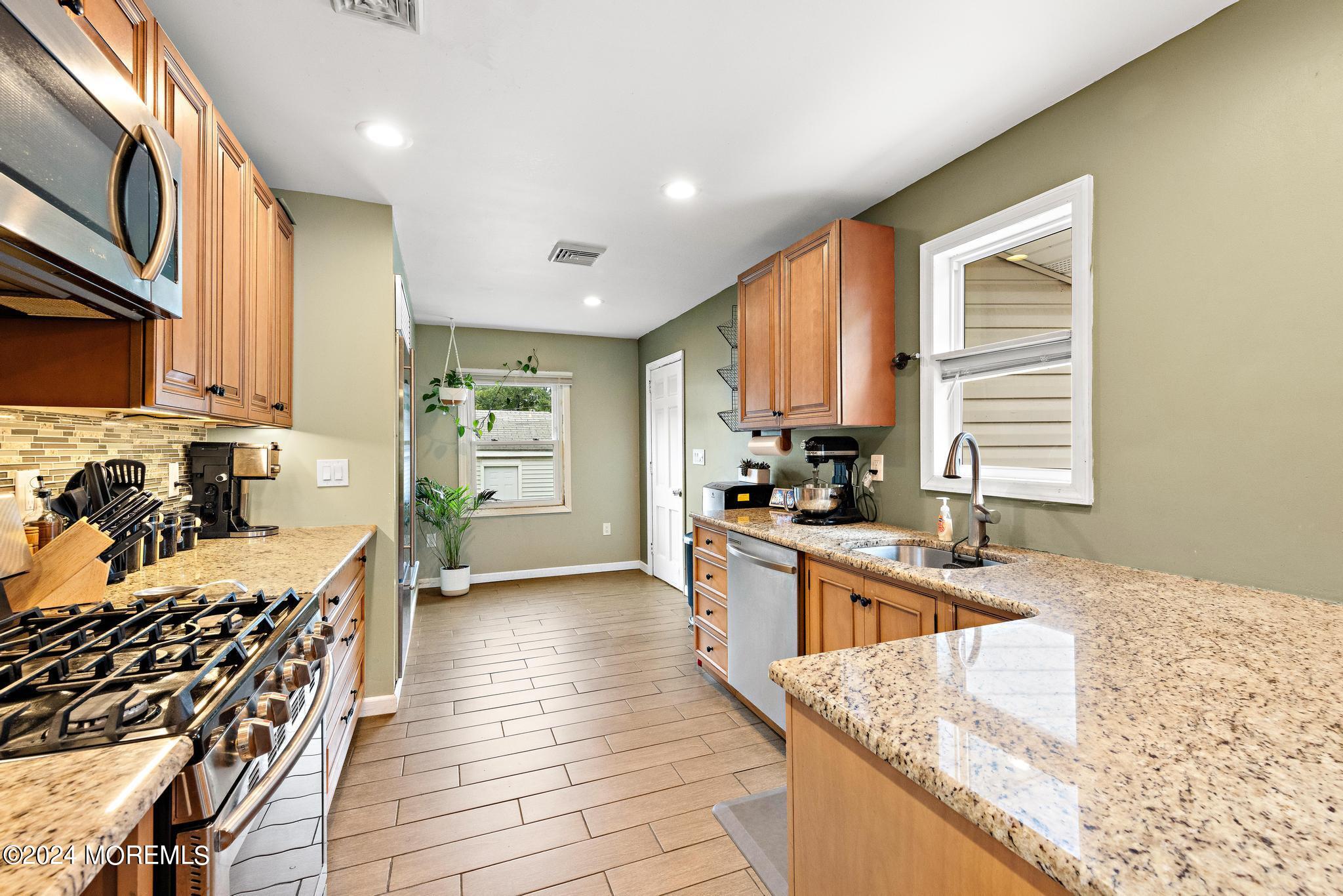 71 Highfield Avenue Matawan, NJ 07747 - Photo 9 of 24 a kitchen with stainless steel appliances granite countertop a stove a sink and a refrigerator