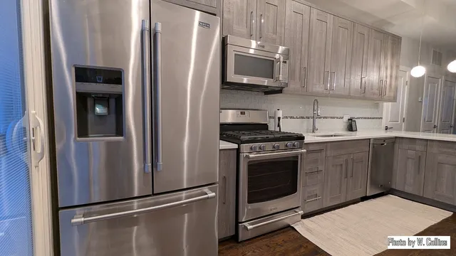 a kitchen with stainless steel appliances granite countertop a refrigerator stove and sink