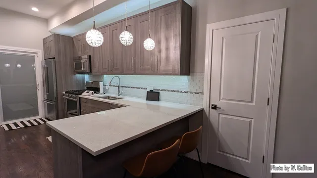 a kitchen with a table a sink and a refrigerator