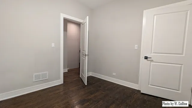 an empty room with wooden floor and closet