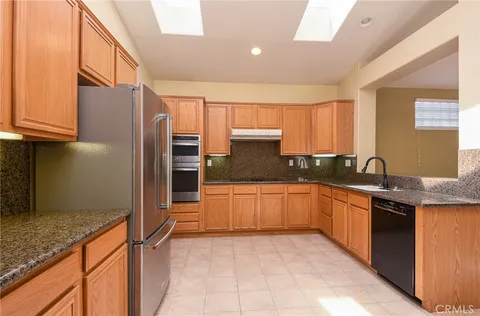 a kitchen with stainless steel appliances granite countertop a refrigerator and a stove top oven