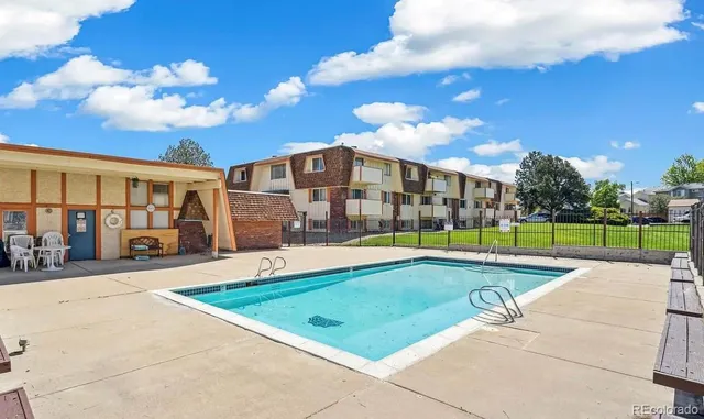 a view of a building with a swimming pool and sitting area