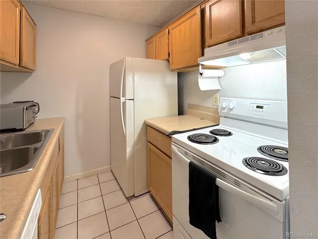 a kitchen with a stove top oven and refrigerator