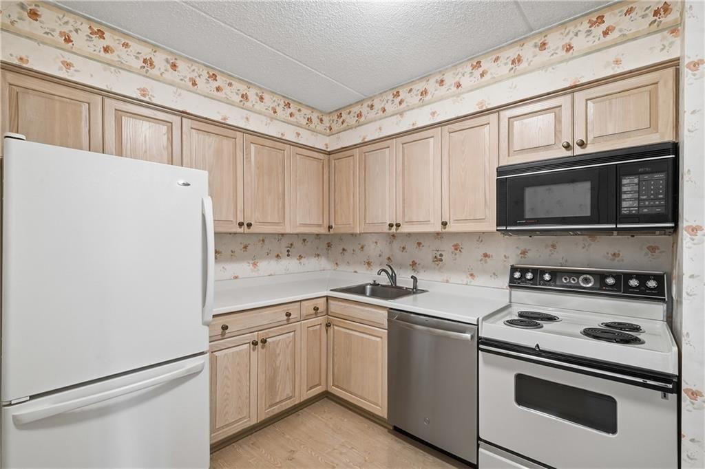 2160 Greentree Road, Unit 705W Pittsburgh, PA 15220 - Photo 12 of 32 a kitchen with stainless steel appliances granite countertop white cabinets a stove a microwave and a refrigerator