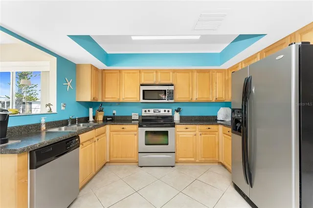 a kitchen with white cabinets and sink