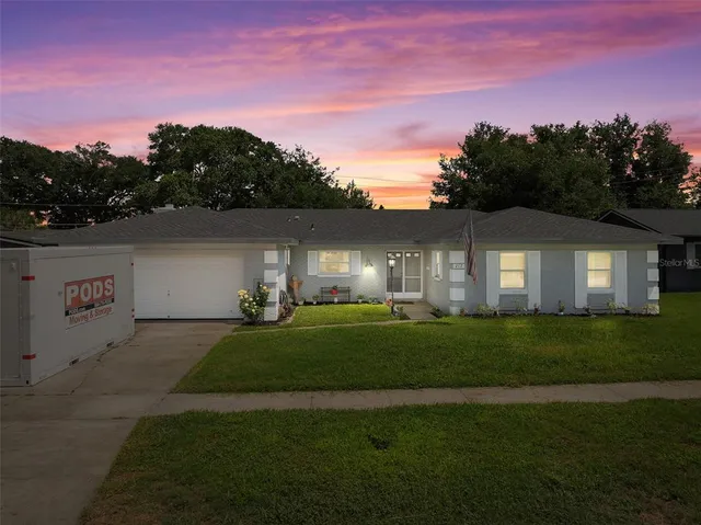a front view of a house with a yard and green space