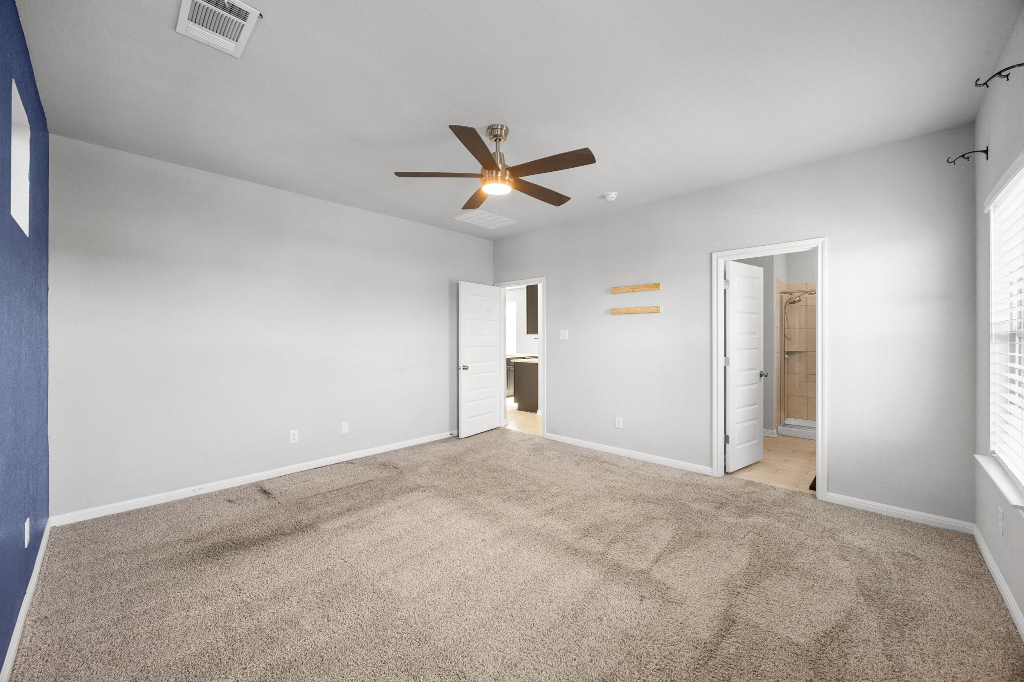 225 Unforgiven Lane Jarrell, TX 76537 - Photo 15 of 30 Unfurnished bedroom featuring carpet, ceiling fan, and ensuite bathroom