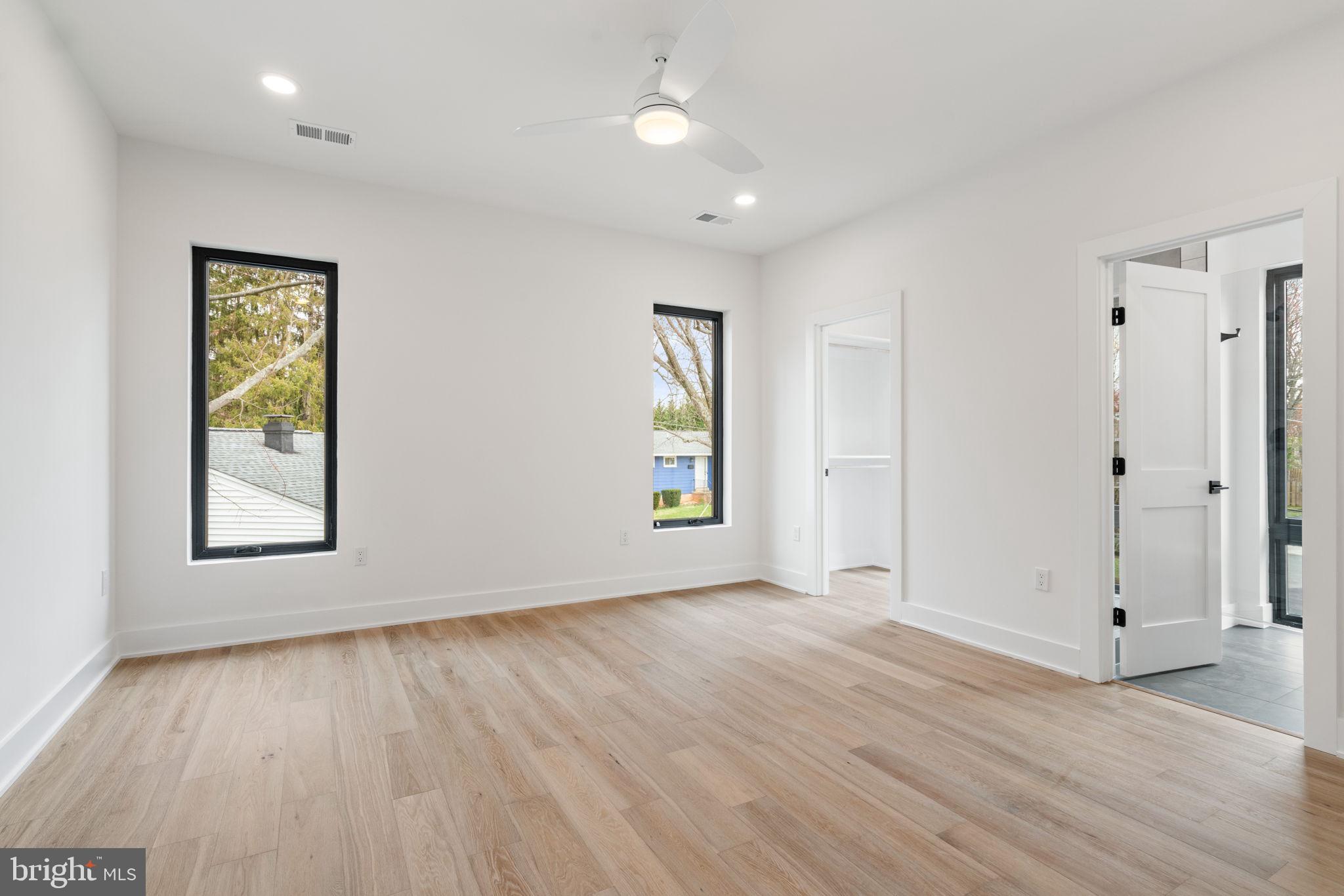 505 Adelman Circle Southwest Vienna, VA 22180 - Photo 44 of 85 an empty room with wooden floor and windows