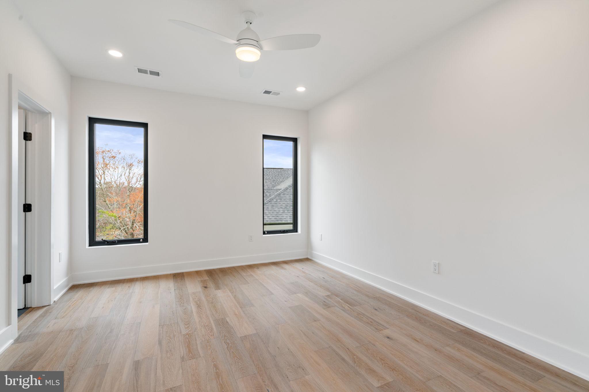 505 Adelman Circle Southwest Vienna, VA 22180 - Photo 48 of 85 an empty room with wooden floor and windows