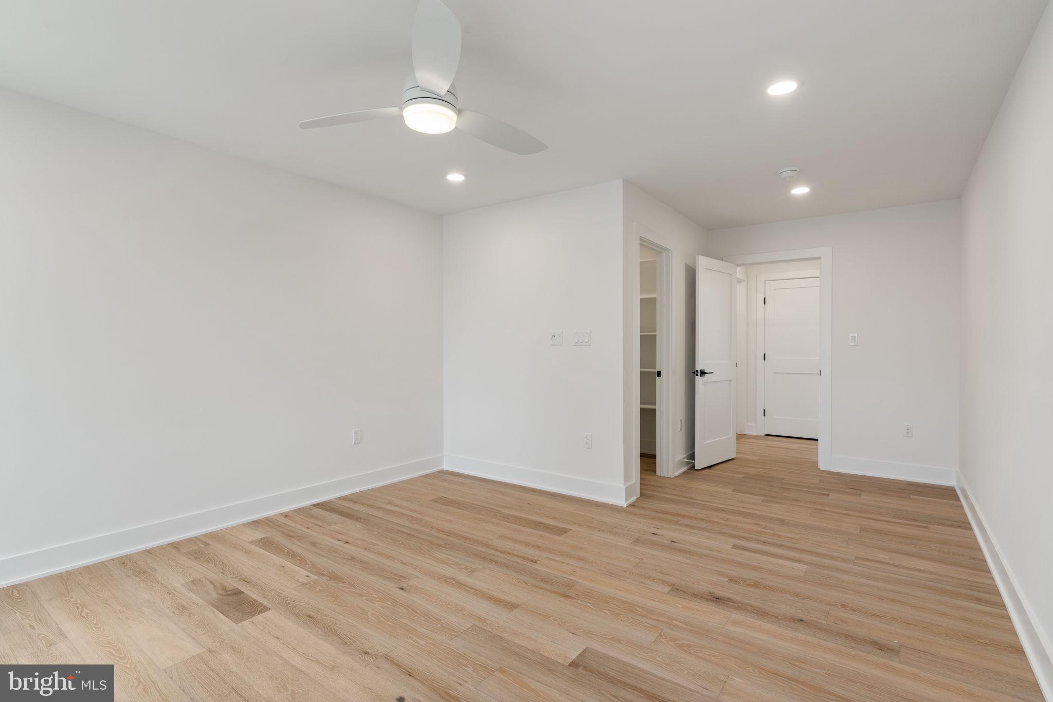 505 Adelman Circle Southwest Vienna, VA 22180 - Photo 64 of 85 a view of an empty room with wooden floor and a ceiling fan