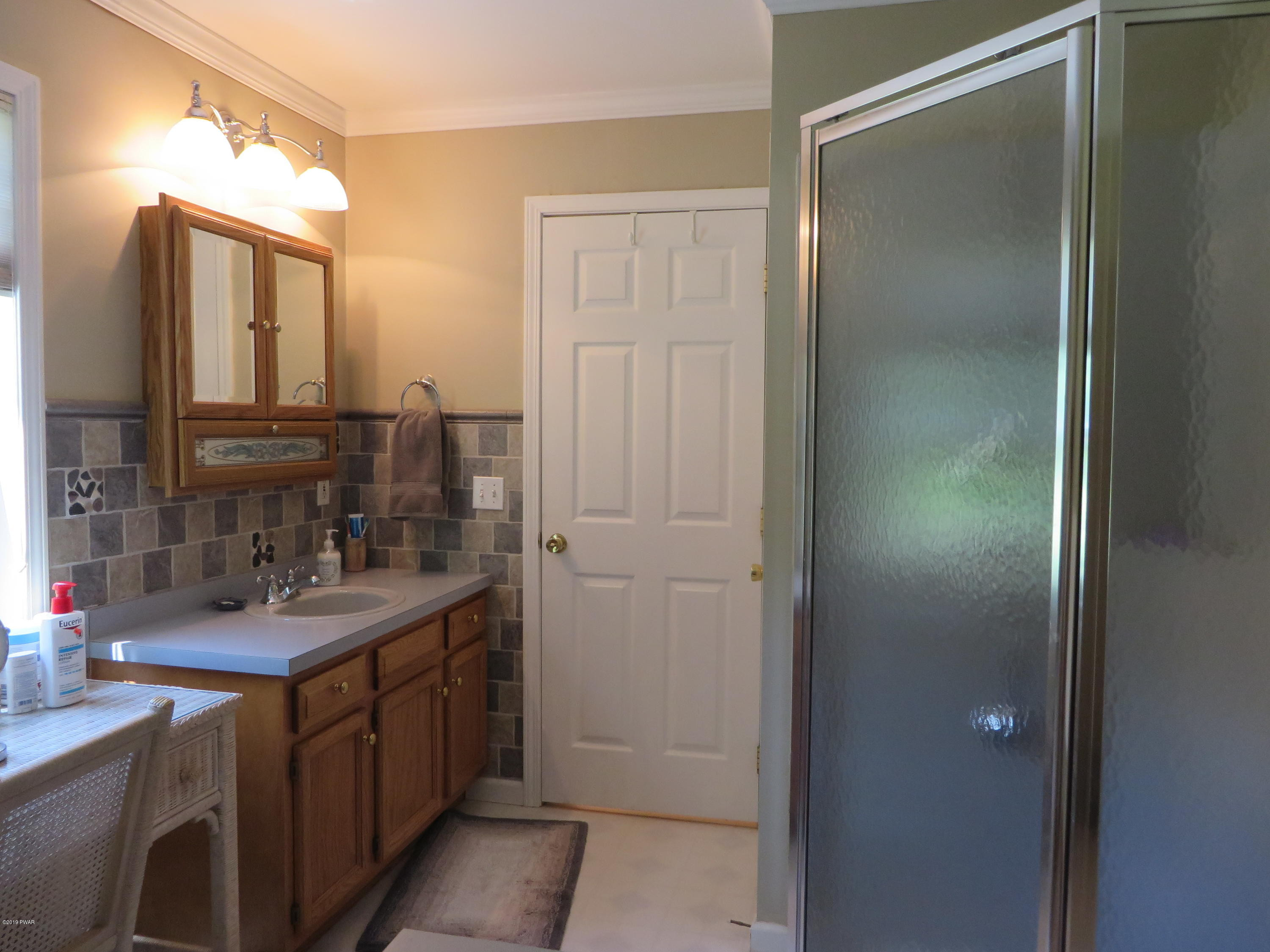 137 Maple Ridge Road Milford, PA 18337 - Photo 46 of 82 a bathroom with a double vanity sink a mirror and a shower